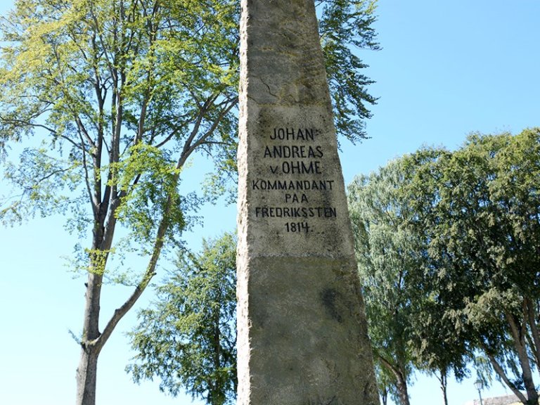 Steinmonument med inskripsjonen 'JOHAN ANDREAS v. OHME KOMMANDANT PAA FREDRIKSTEN 1814'.