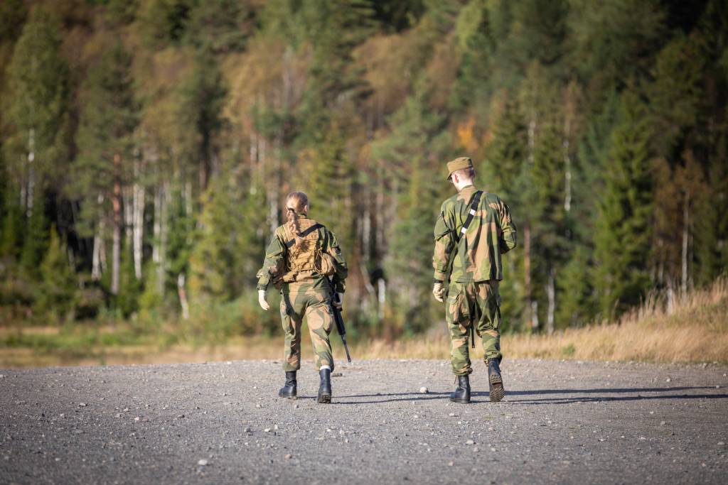 To soldater som går på et skyte- og øvningsfelt. 